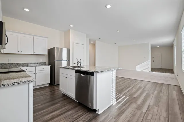 a kitchen with stainless steel appliances granite countertop a stove a sink and a refrigerator