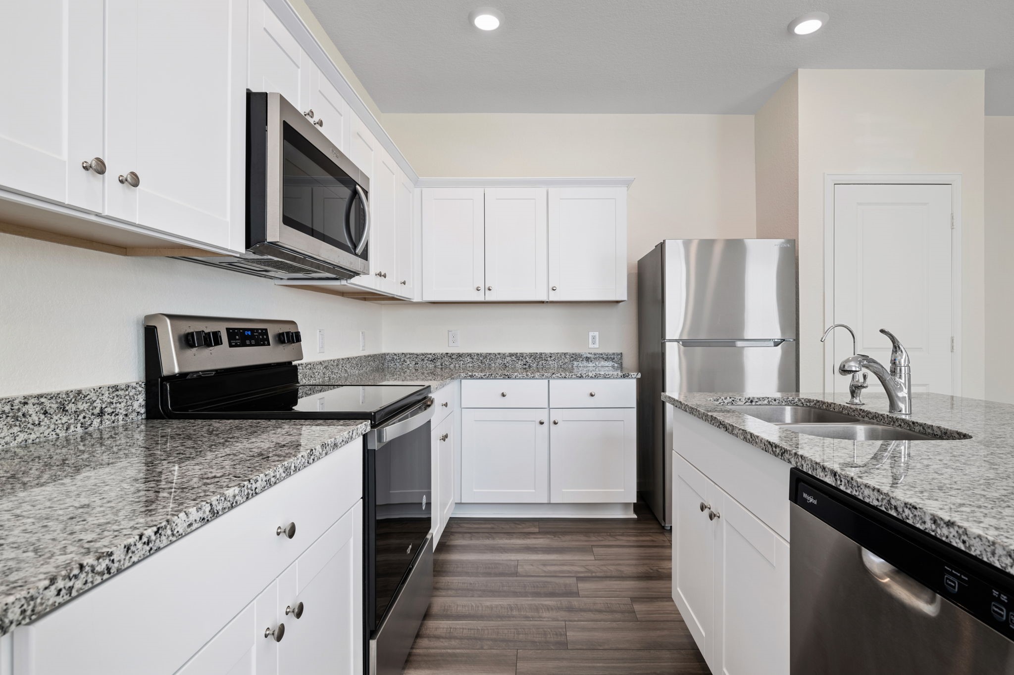 614 Edge Lake Court Montgomery, TX 77316 - Photo 7 of 27 a kitchen with stainless steel appliances granite countertop a sink stove microwave and refrigerator