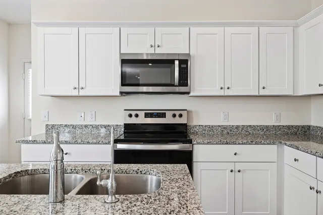 a kitchen with stainless steel appliances granite countertop a sink a stove and cabinets