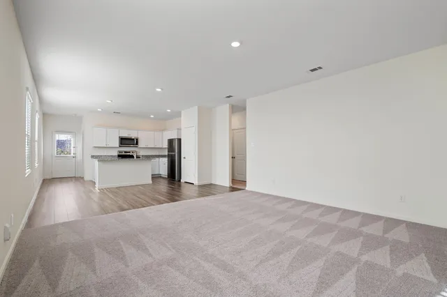 a view of kitchen with refrigerator stove and wooden floor