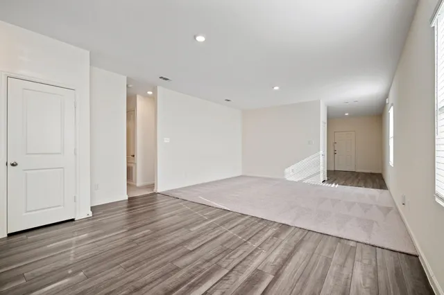 a view of an empty room with wooden floor