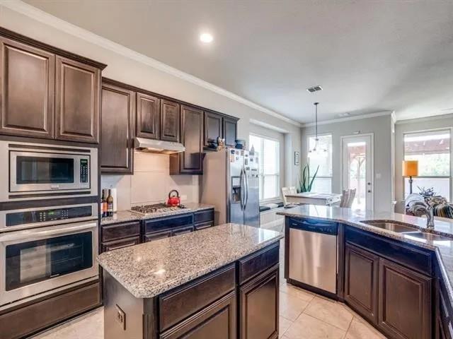 321 Valentino Way Grand Prairie, TX 75052 - Photo 11 of 24 a kitchen with granite countertop stainless steel appliances and wooden cabinets