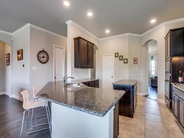 321 Valentino Way Grand Prairie, TX 75052 - Photo 13 of 24 a kitchen with granite countertop a sink and a refrigerator