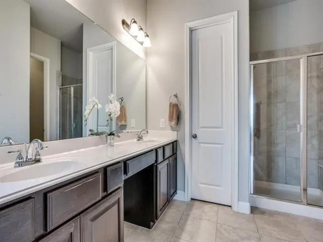 321 Valentino Way Grand Prairie, TX 75052 - Photo 17 of 24 a bathroom with a double vanity sink a mirror and a shower