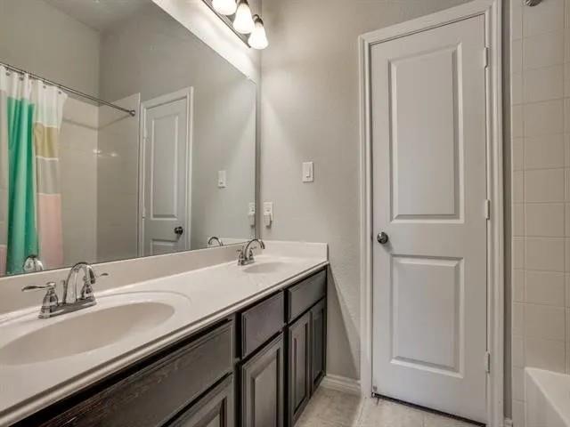 321 Valentino Way Grand Prairie, TX 75052 - Photo 22 of 24 a bathroom with a double vanity sink and a mirror