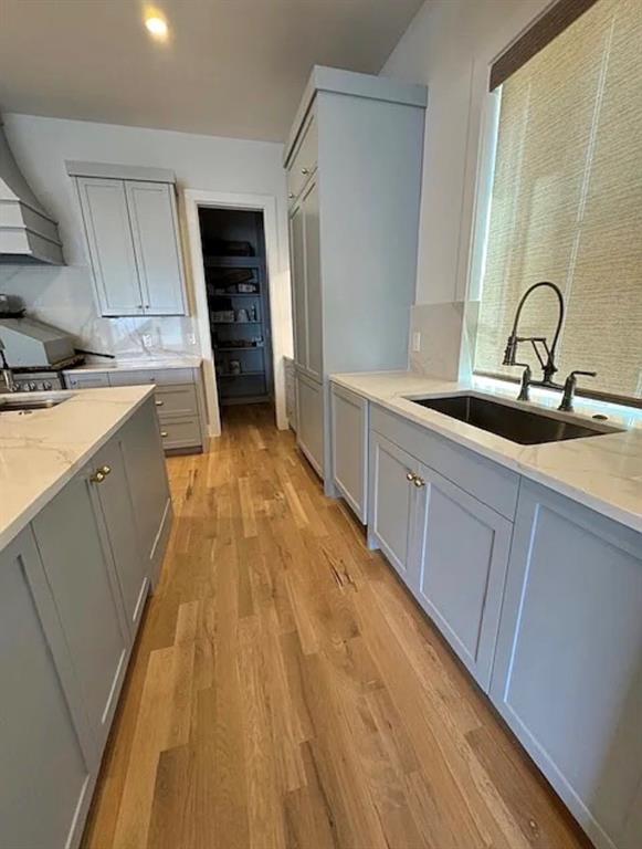 5800 Goodwin Avenue Dallas, TX 75206 - Photo 11 of 39 The kitchen features light-colored cabinetry with gold-toned hardware, white countertops, and light wood flooring