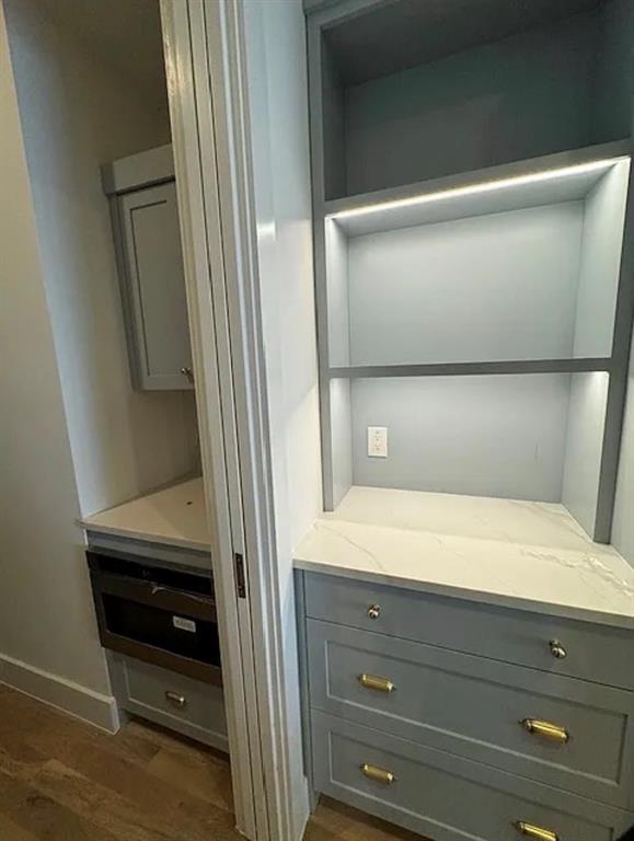 5800 Goodwin Avenue Dallas, TX 75206 - Photo 12 of 39 Custom built-in cabinetry with marble-look countertops, illuminated shelving, and integrated drawers