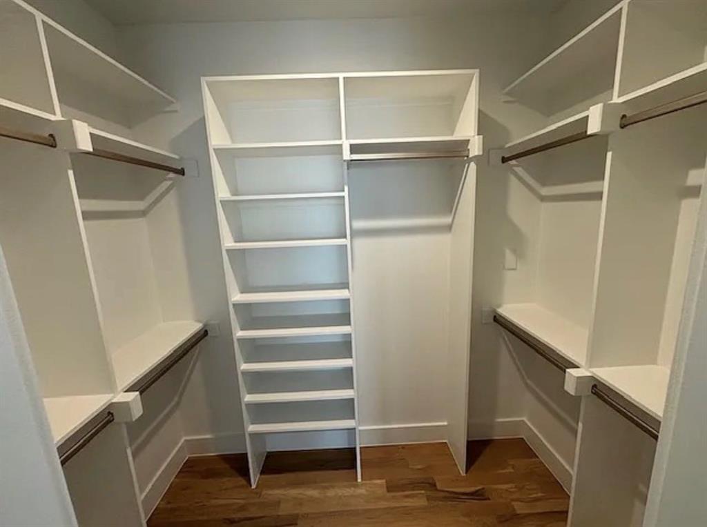 5800 Goodwin Avenue Dallas, TX 75206 - Photo 34 of 39 Well-appointed closet featuring extensive built-in shelving, hanging rods, and wood flooring