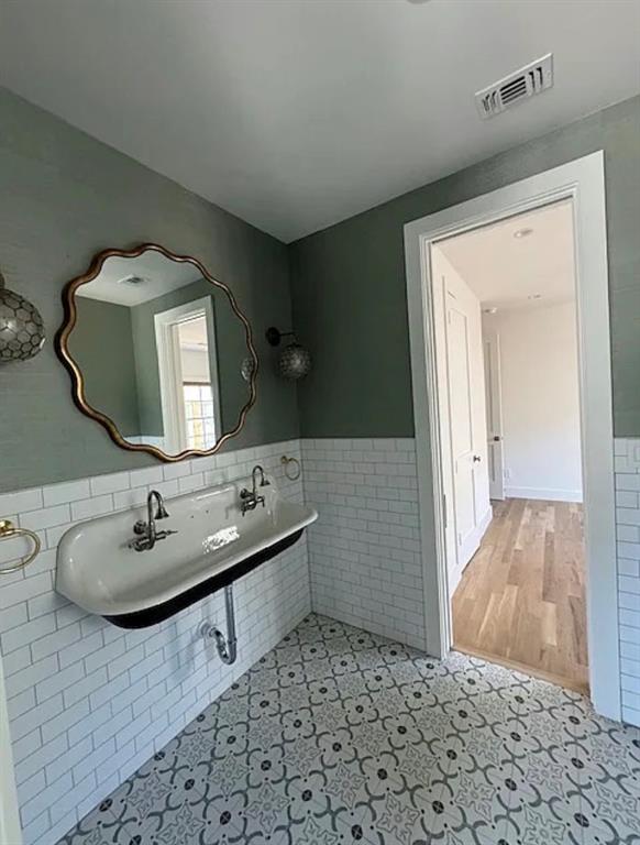 5800 Goodwin Avenue Dallas, TX 75206 - Photo 36 of 39 Bathroom featuring a unique double sink, decorative patterned floor tiles, and subway tile wainscoting