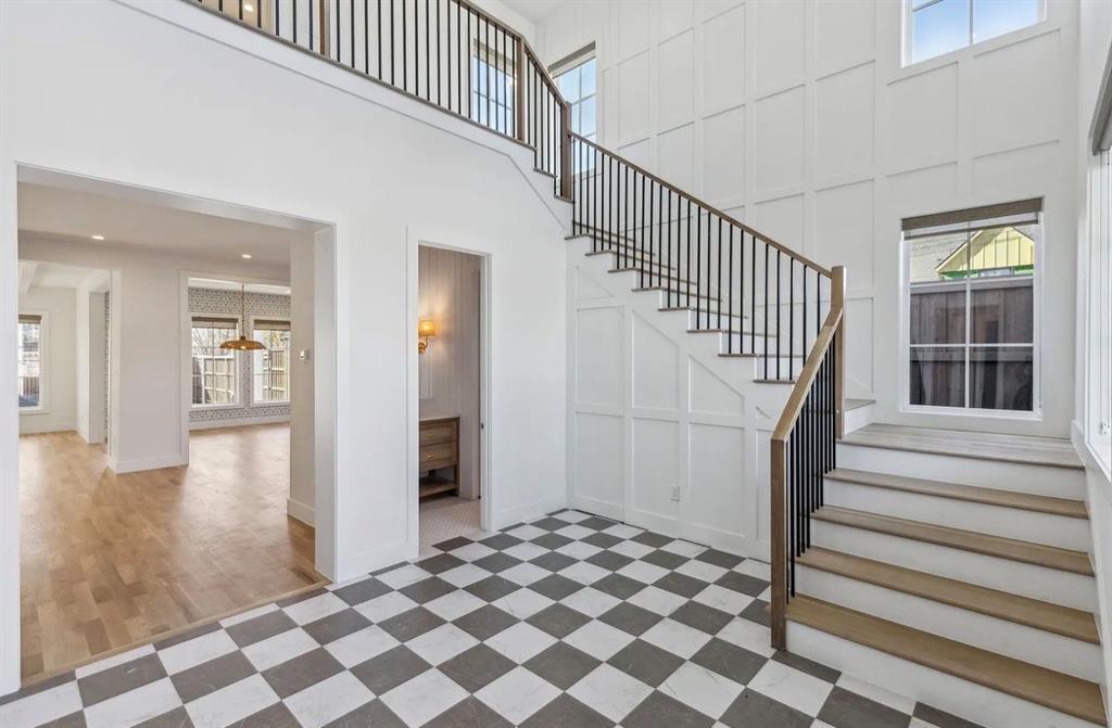 5800 Goodwin Avenue Dallas, TX 75206 - Photo 4 of 39 A grand entry foyer featuring a striking staircase with a dark metal railing, an open concept layout, and checkered flooring