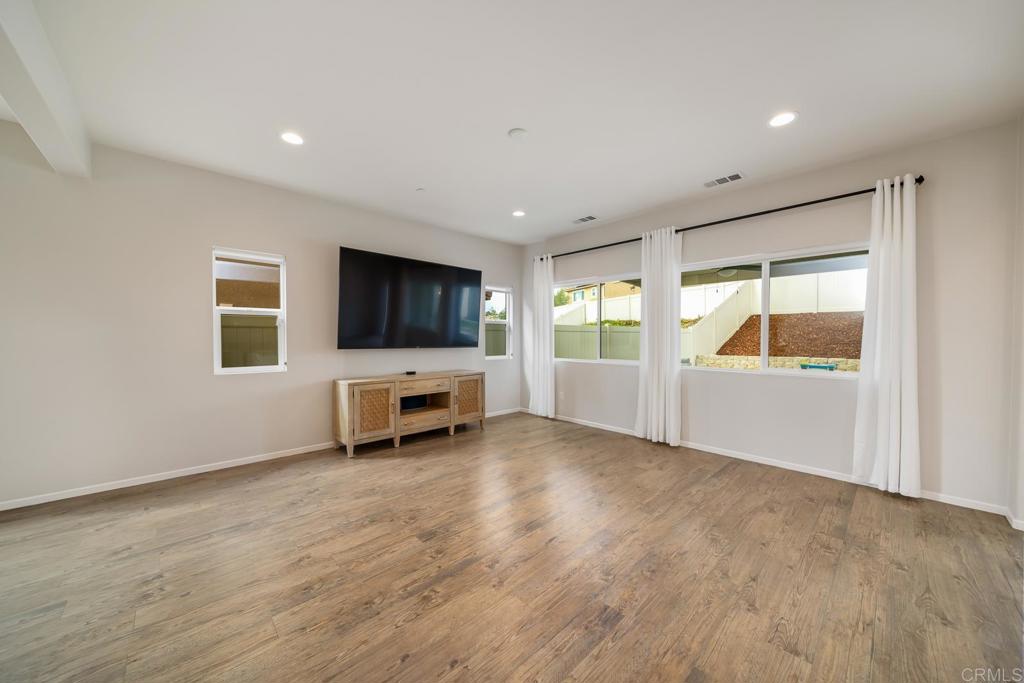 352 Misaki Way Fallbrook, CA 92028 - Photo 11 of 68 a view of an empty room with a window and wooden floor