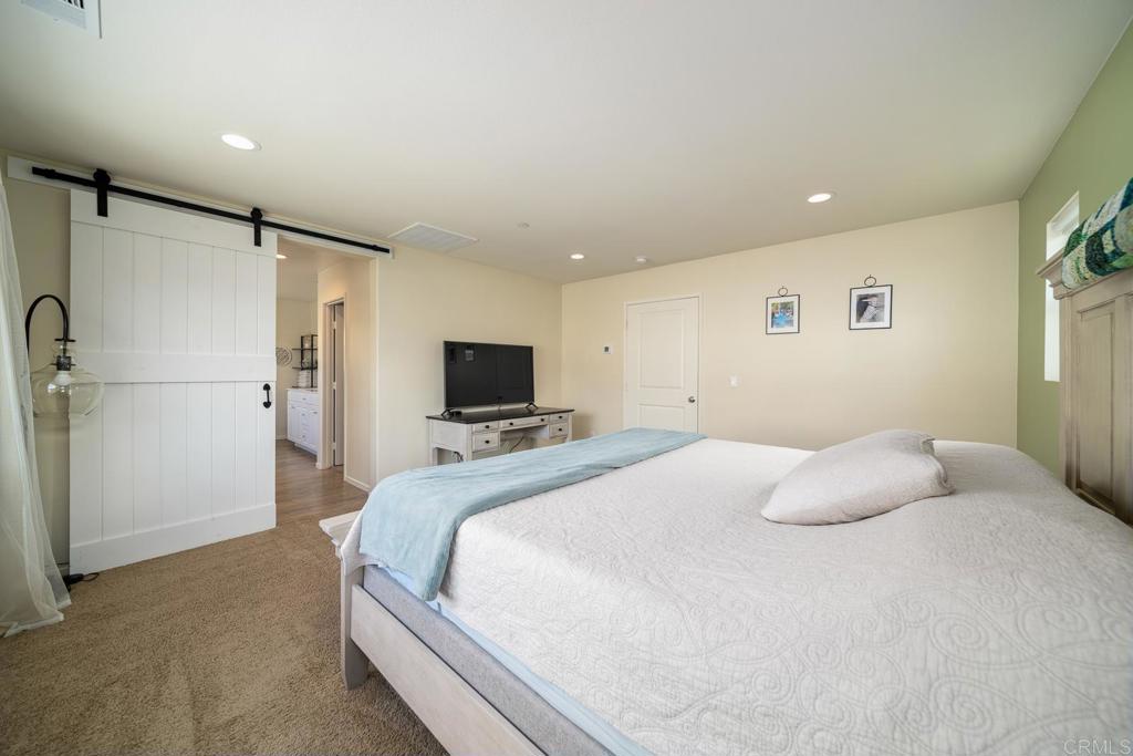 352 Misaki Way Fallbrook, CA 92028 - Photo 40 of 68 a bedroom with a bed and a flat screen tv