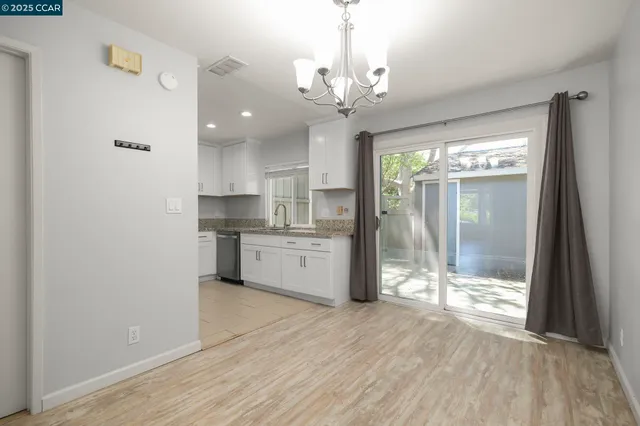 a view of a kitchen with a sink and dishwasher with wooden floor