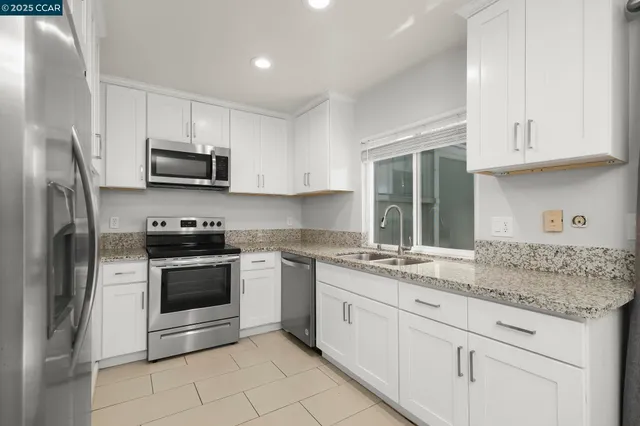 a kitchen with stainless steel appliances granite countertop a sink stove and refrigerator