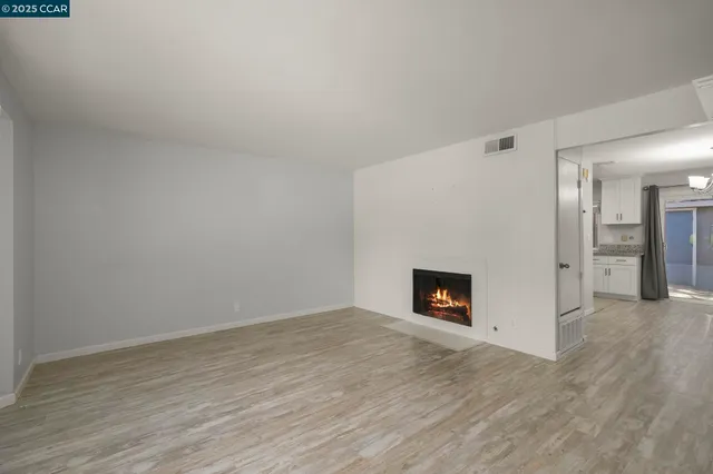 a view of an empty room with window and fire place