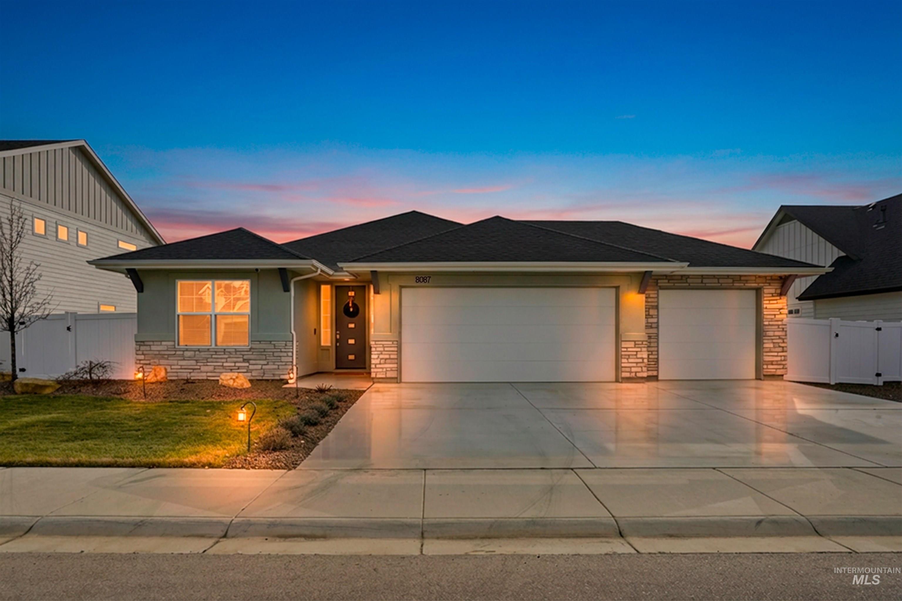 View of front of home featuring a gate, stone siding, a garage, and concrete driveway