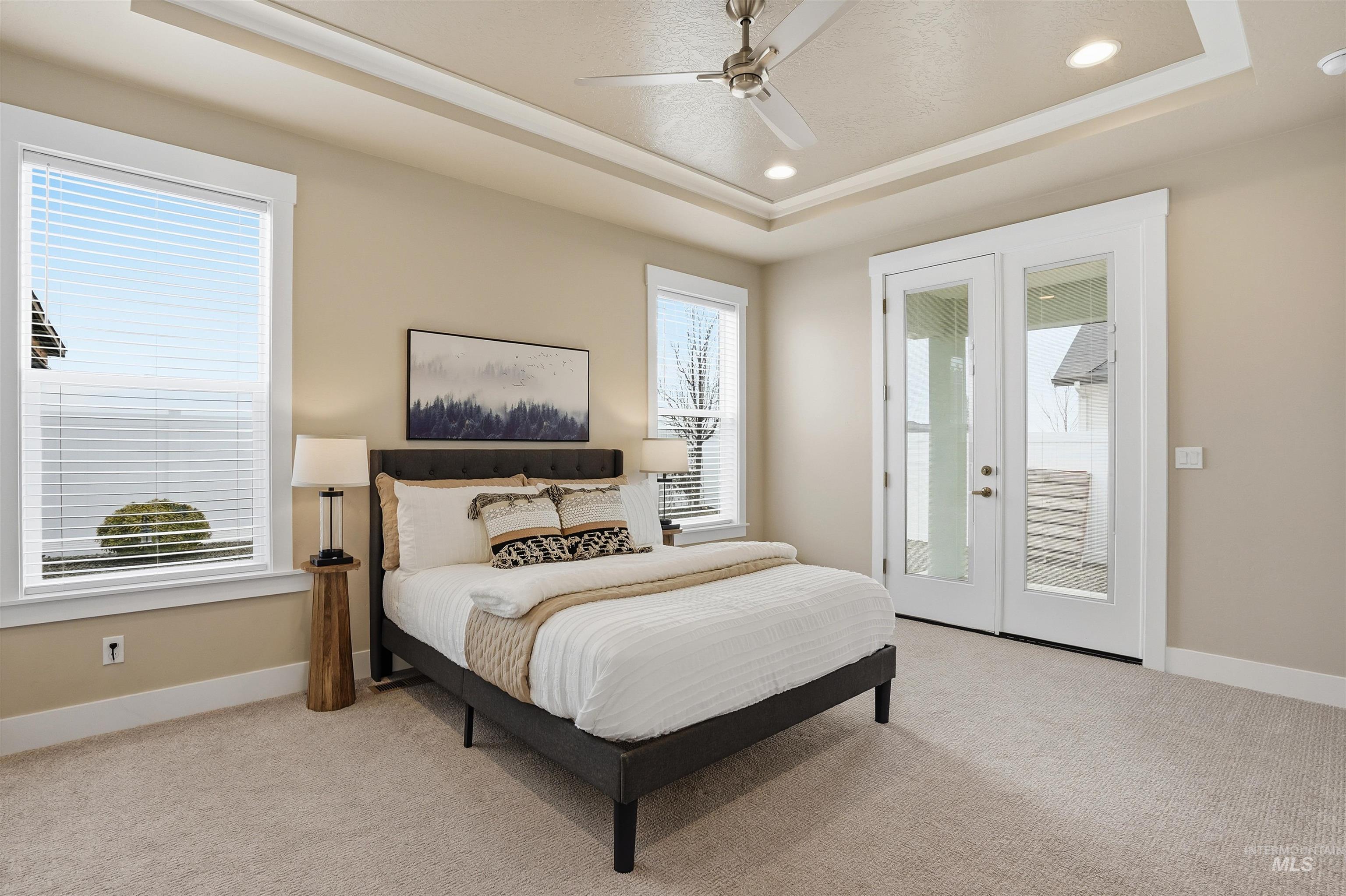 8087 Tandy Cove Street Middleton, ID 83644 - Photo 20 of 50 Bedroom featuring access to exterior, light carpet, recessed lighting, french doors, and a tray ceiling