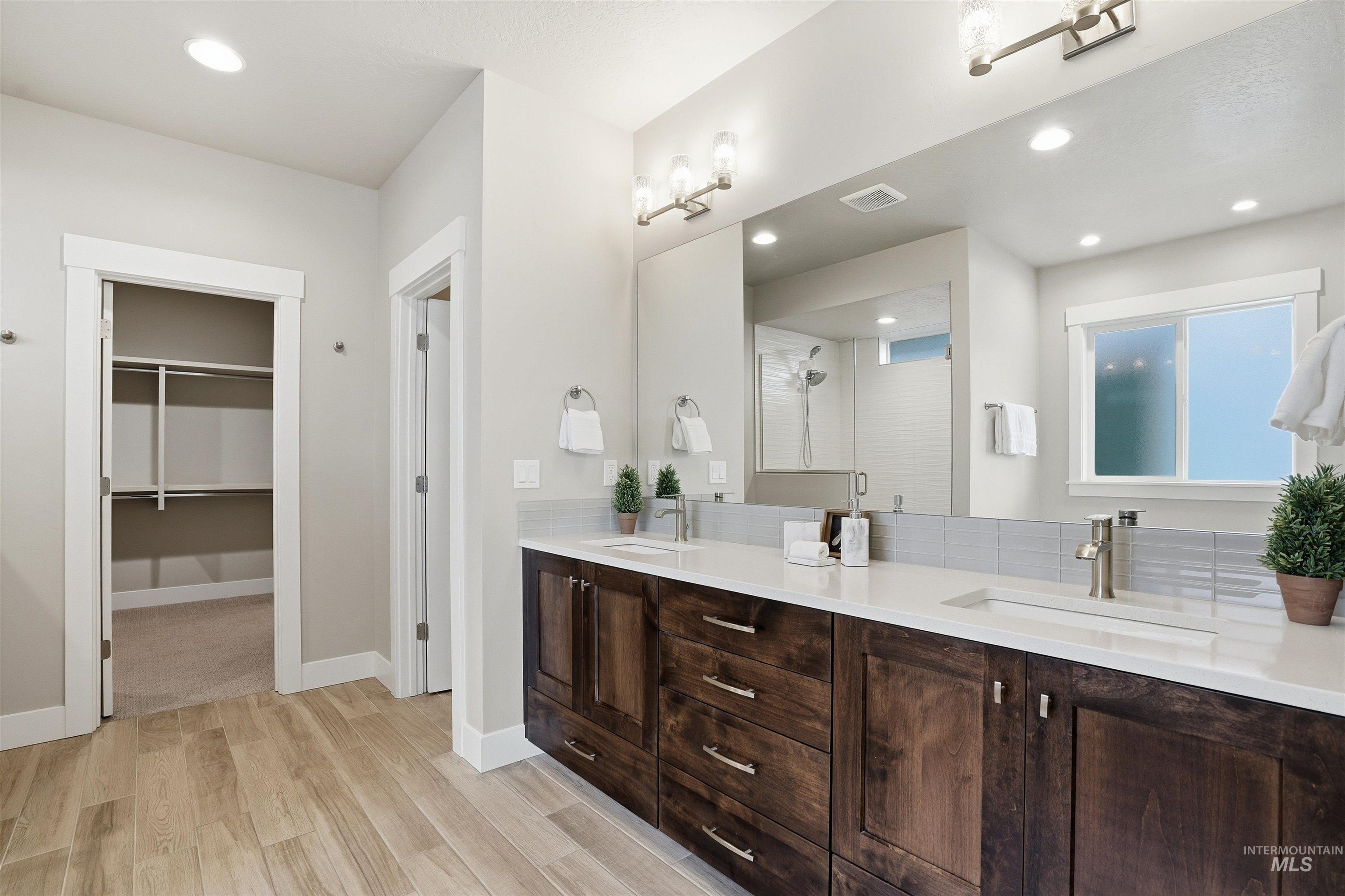 8087 Tandy Cove Street Middleton, ID 83644 - Photo 21 of 50 Full bathroom with a stall shower, double vanity, light wood-style floors, a walk in closet, and recessed lighting