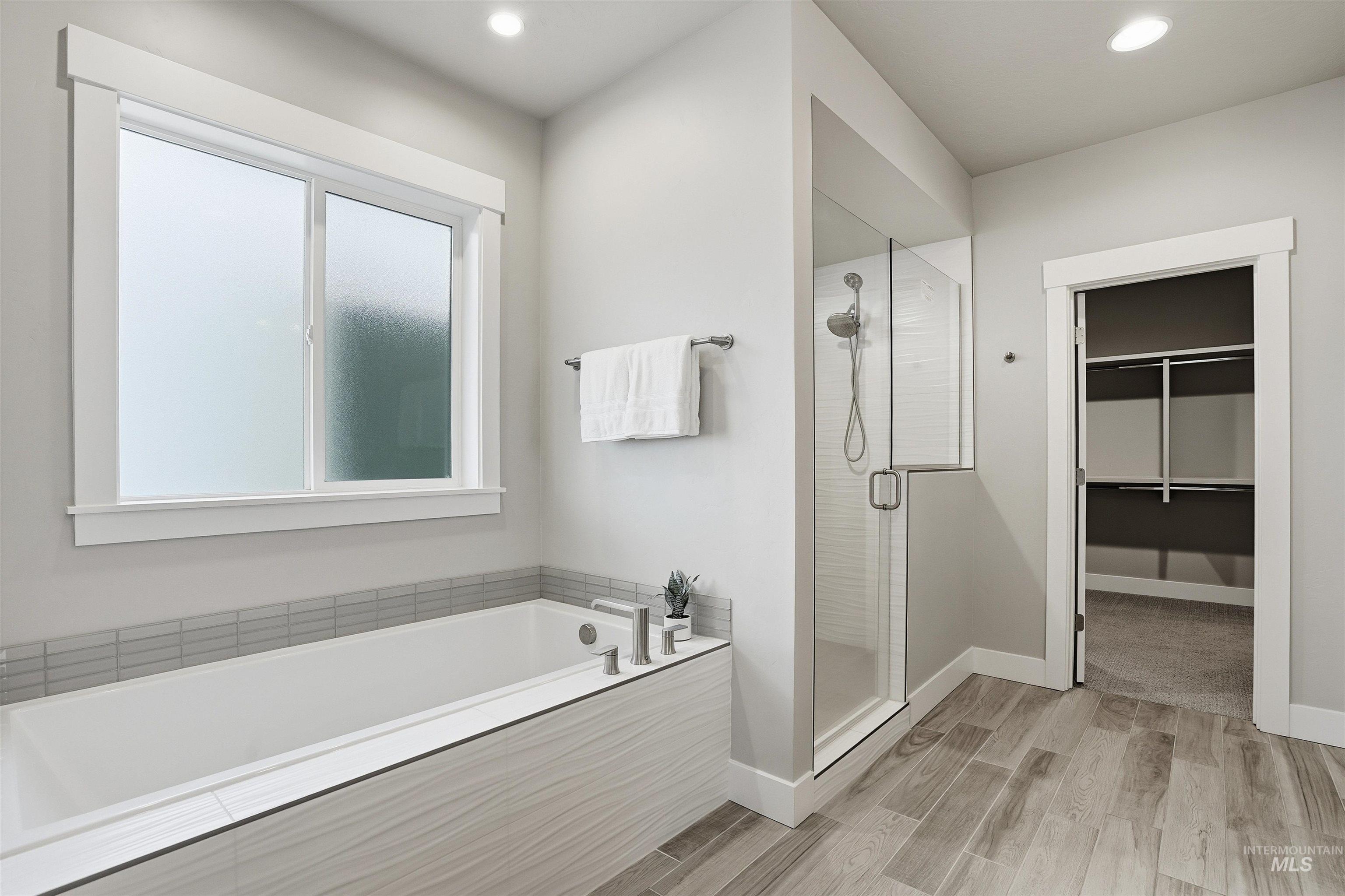 8087 Tandy Cove Street Middleton, ID 83644 - Photo 22 of 50 Full bathroom featuring a stall shower, wood finish floors, a bath, a walk in closet, and recessed lighting