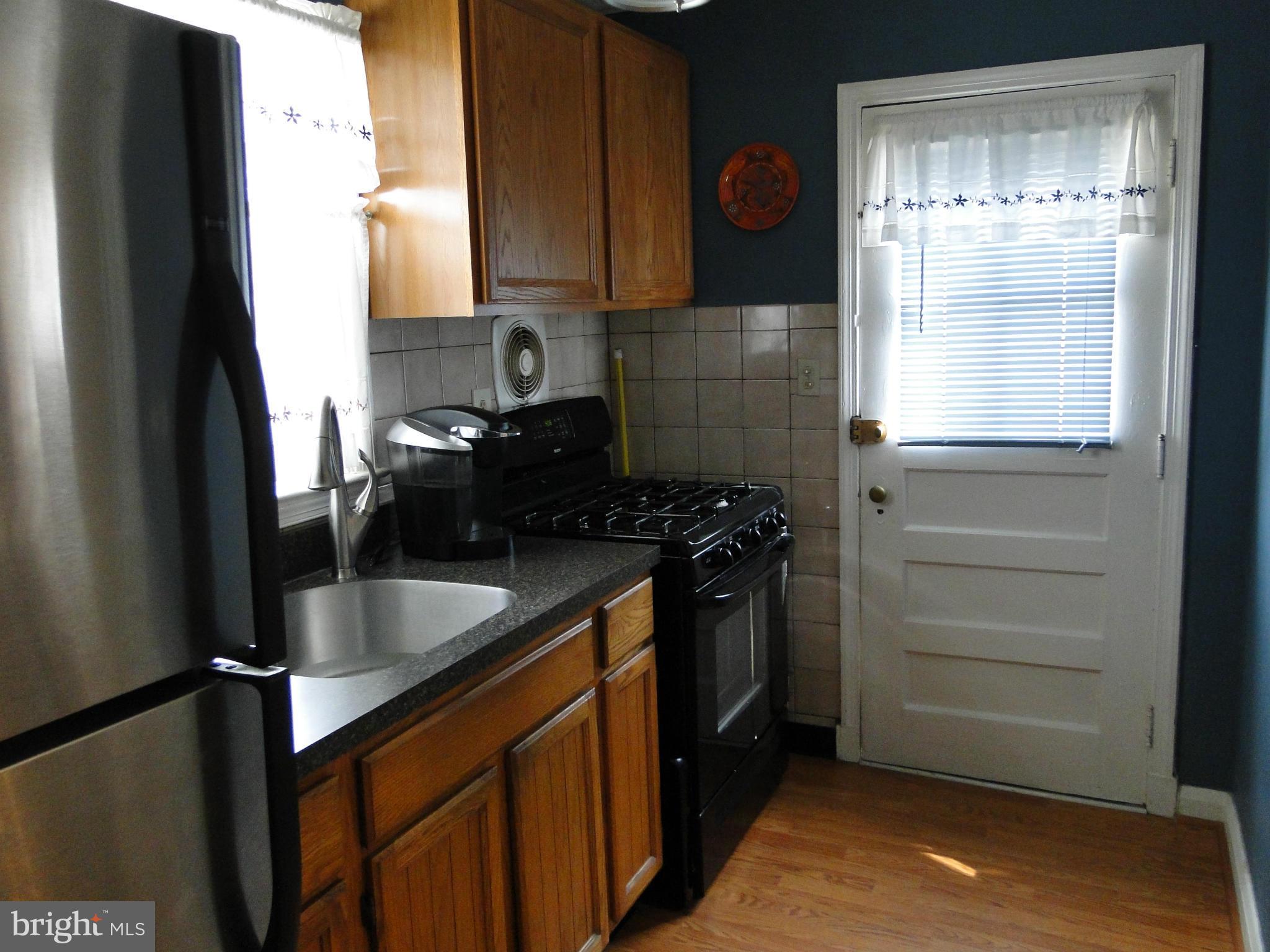 8419 Oakleigh Road Baltimore, MD 21234 - Photo 16 of 30 a kitchen with granite countertop a refrigerator and a window