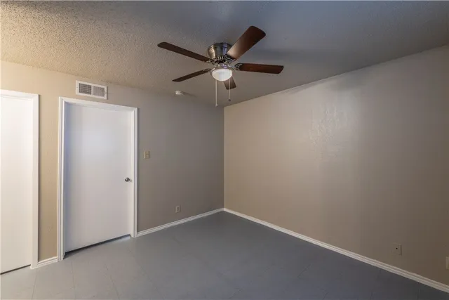 an empty room and chandelier fan