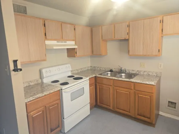 a kitchen with granite countertop white cabinets and white appliances