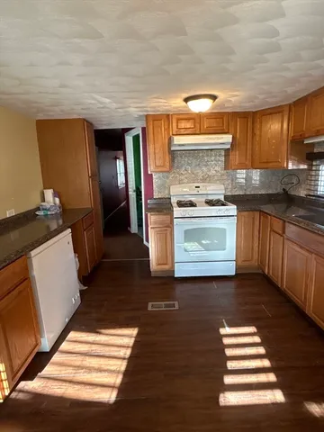 a kitchen with granite countertop stainless steel appliances and wooden cabinets