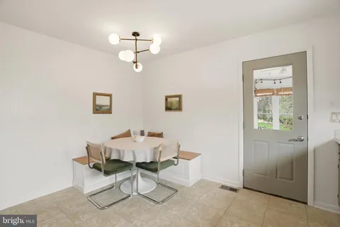 a dining room with wooden floor and a chandelier