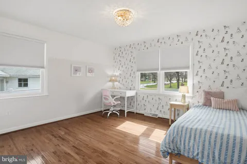 a bedroom with 2 bed and a window