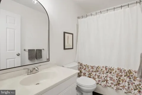 a bathroom with a sink toilet and mirror