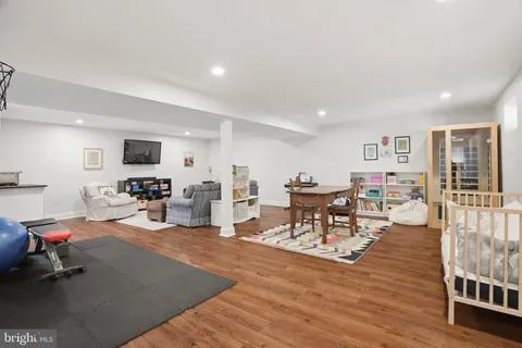 a living room with furniture a wooden floor and a sink
