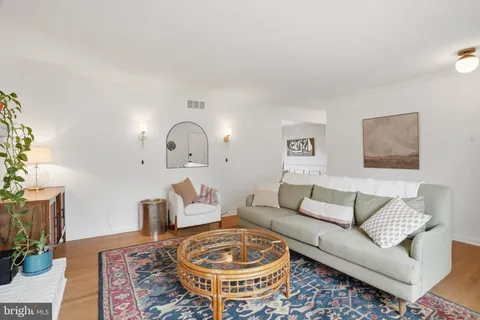 a living room with furniture a rug and a lamp
