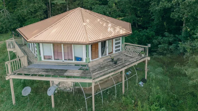 a roof deck with table and chairs under an umbrella