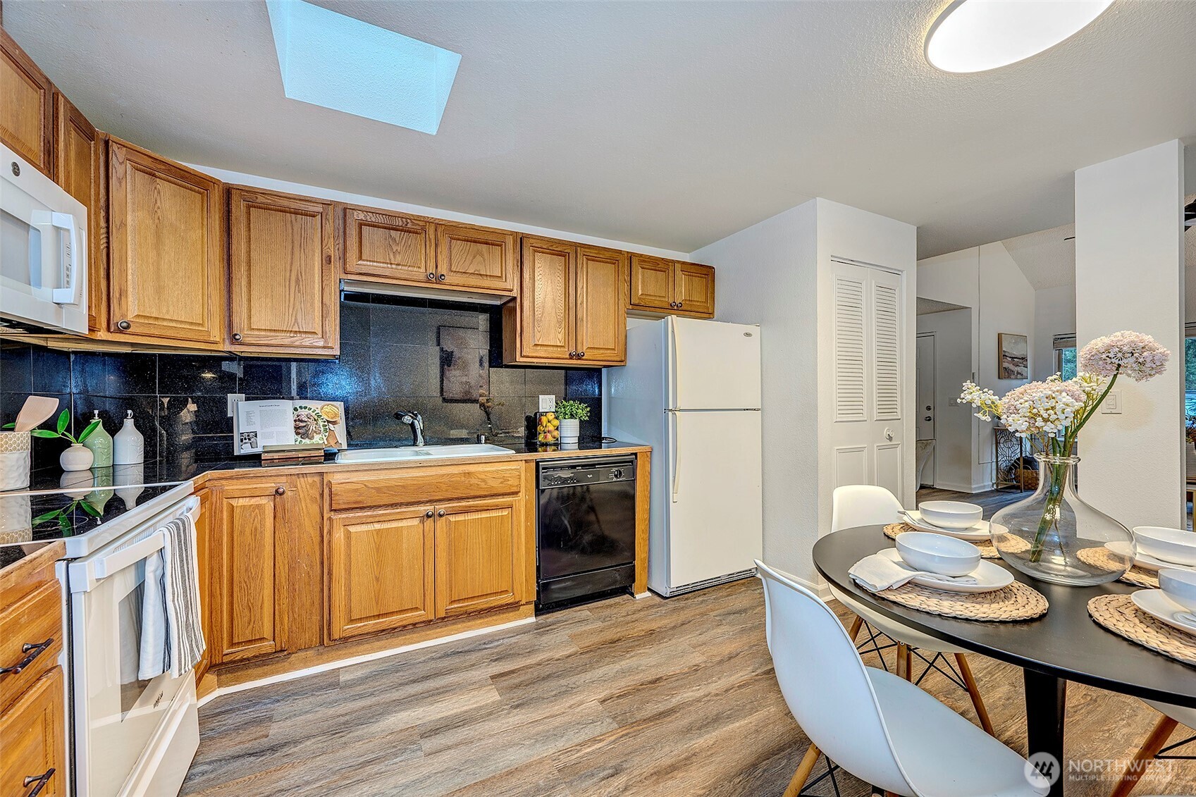 4308 Northeast Sunset Boulevard, Unit P1 Renton, WA 98059 - Photo 5 of 20 a kitchen with stainless steel appliances granite countertop a refrigerator a stove top oven a sink dishwasher and wooden cabinets with wooden floor