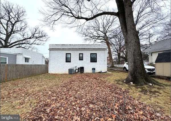a white house that has a tree in front of it