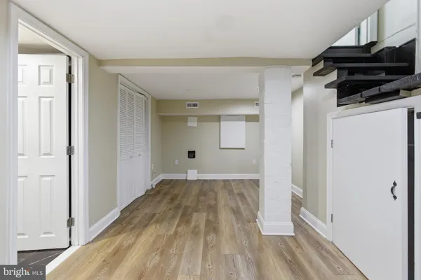 a view of a room with wooden floor and a window