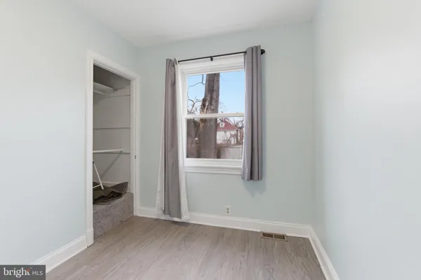 a view of hallway with closet and wooden floor