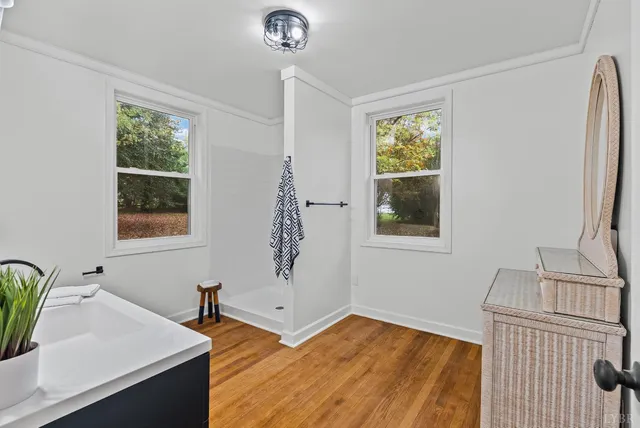 a view of a bedroom with a window and wooden floor