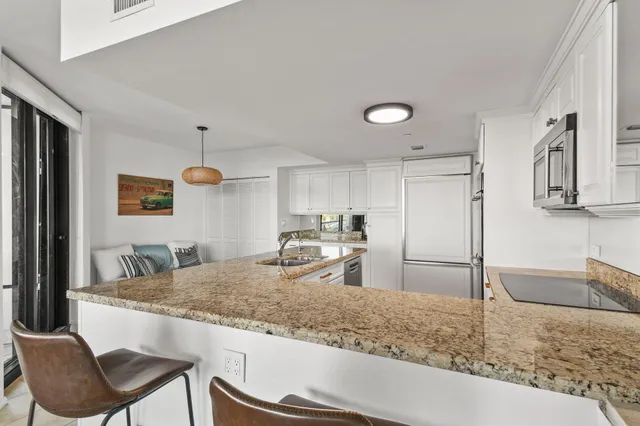 a kitchen with stainless steel appliances granite countertop a refrigerator and a stove top oven