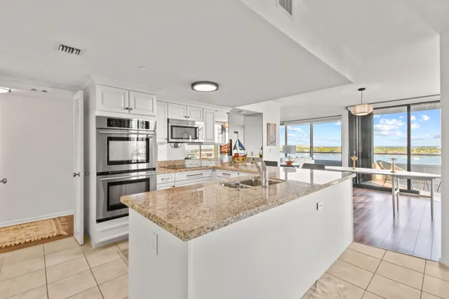a kitchen with granite countertop a sink and white stainless steel appliances