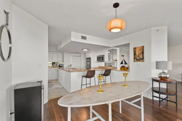 a dining room with wooden floor a chandelier a wooden table and chairs