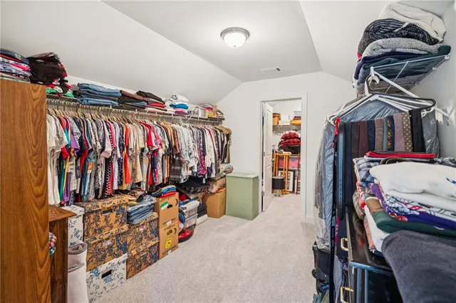 a view of walk in closet with clothes
