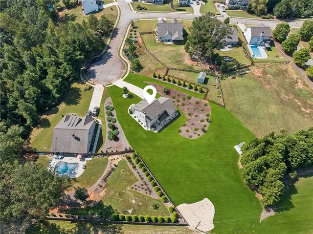 an aerial view of a house with a garden and swimming pool