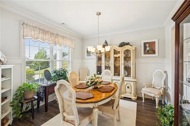 a dining room with furniture a chandelier and wooden floor