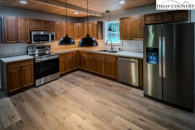 a kitchen with stainless steel appliances granite countertop a sink a stove a refrigerator and cabinets