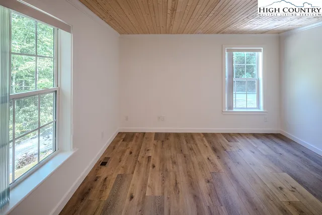 a view of a room with wooden floor and windows