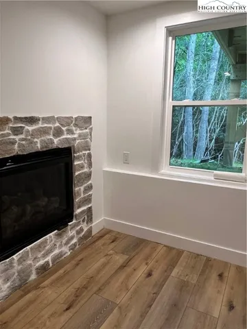 a view of empty room with wooden floor and fireplace