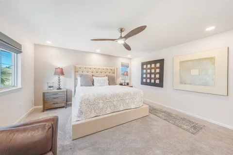 a bedroom with a large bed and a chandelier