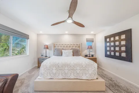 a bedroom with a large bed and a chandelier