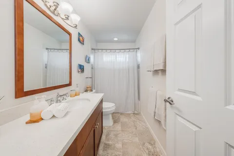 a bathroom with a sink a toilet a mirror and shower